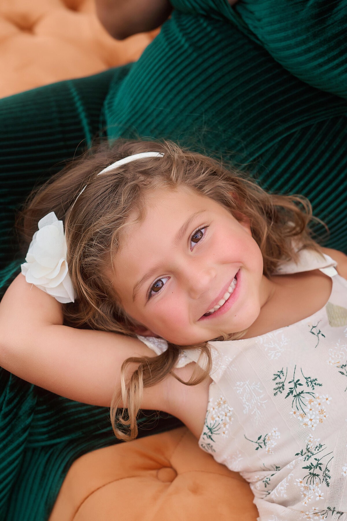 A little girl resting her head in her mother’s lap